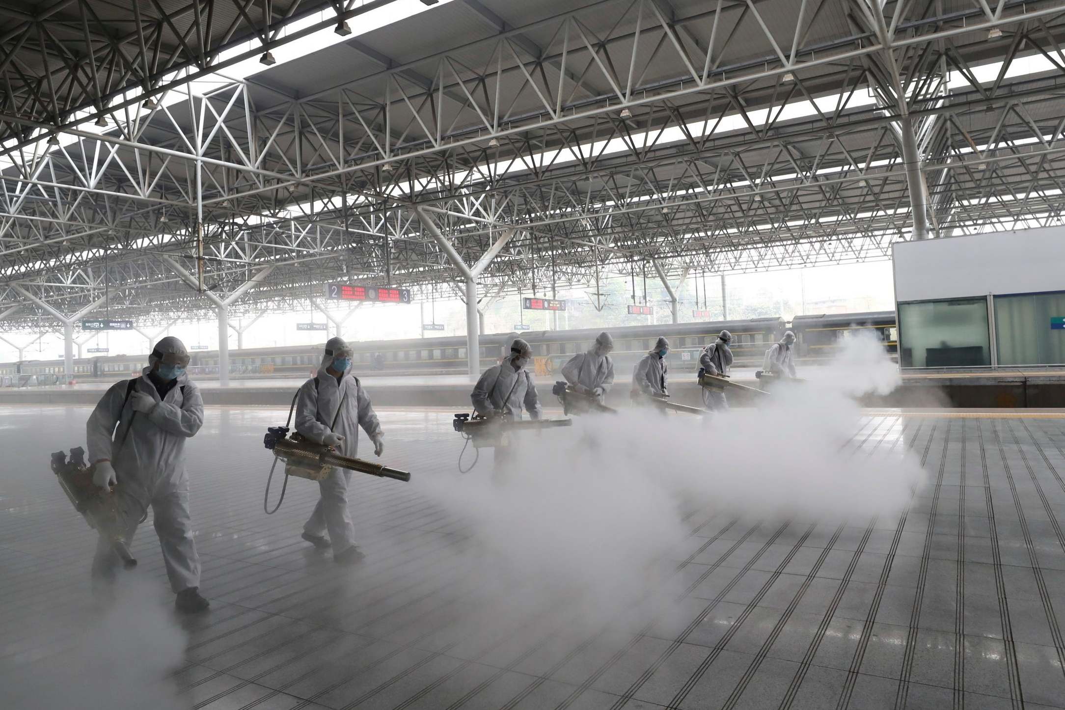 Firefighters disinfect a train platform in China, where public transport has partially reopened after months of lockdown