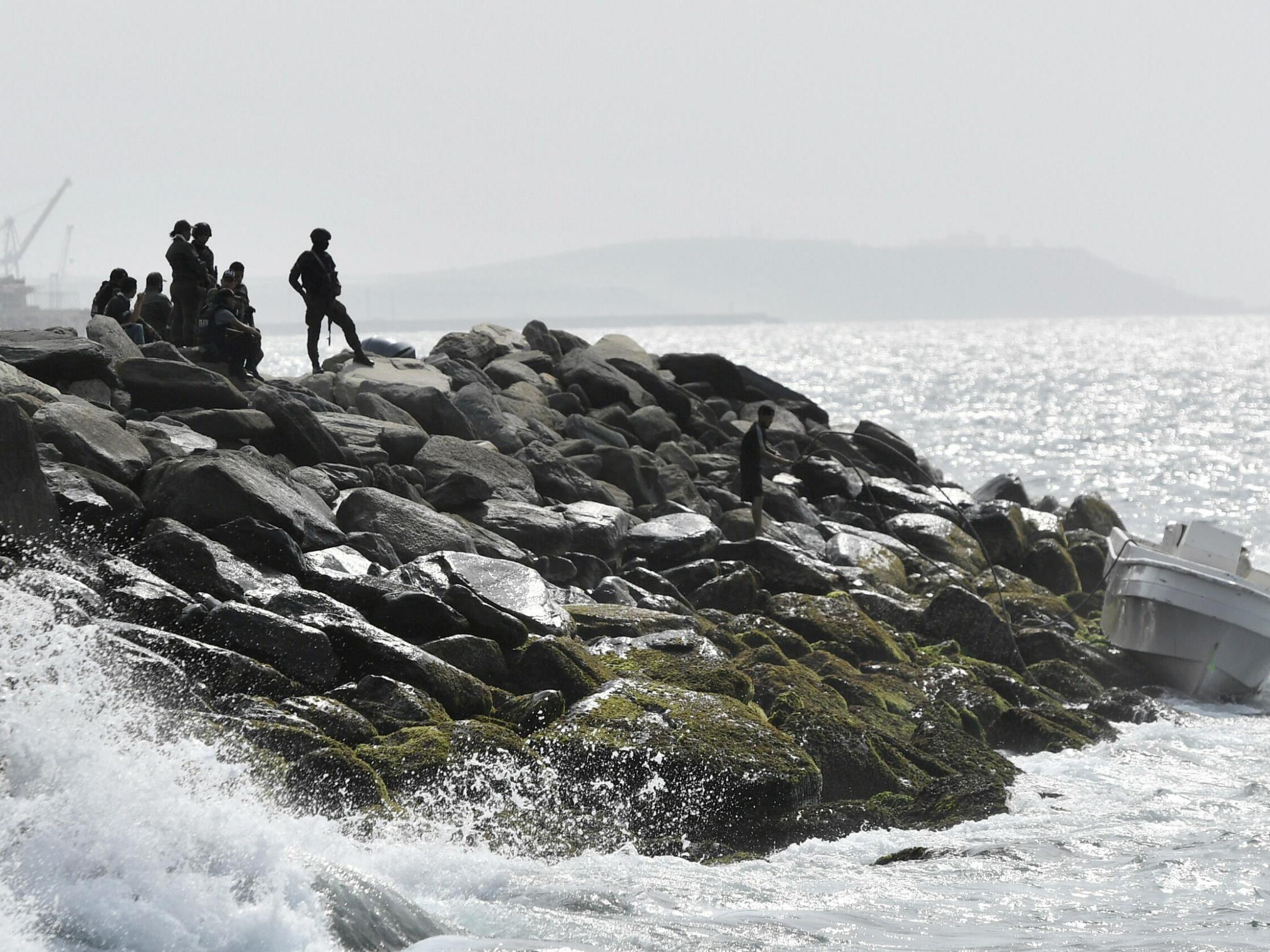 Security forces guard the shore area and a boat in which authorities claim a group of armed men landed in the port city of La Guaira in Venezuela on 3 May