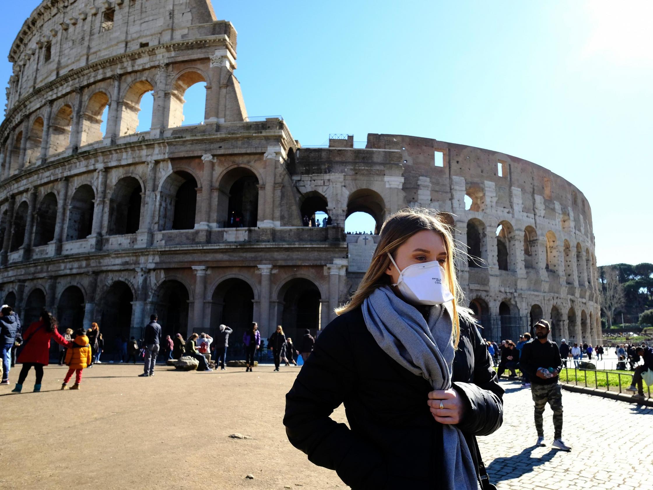 Tourists wear face masks outside the Colosseum in Rome
