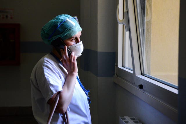 A medical worker wearing a face mask talks on her mobile phone inside the new coronavirus intensive care unit of the Brescia Poliambulanza hospital, Lombardy, on March 17, 2020