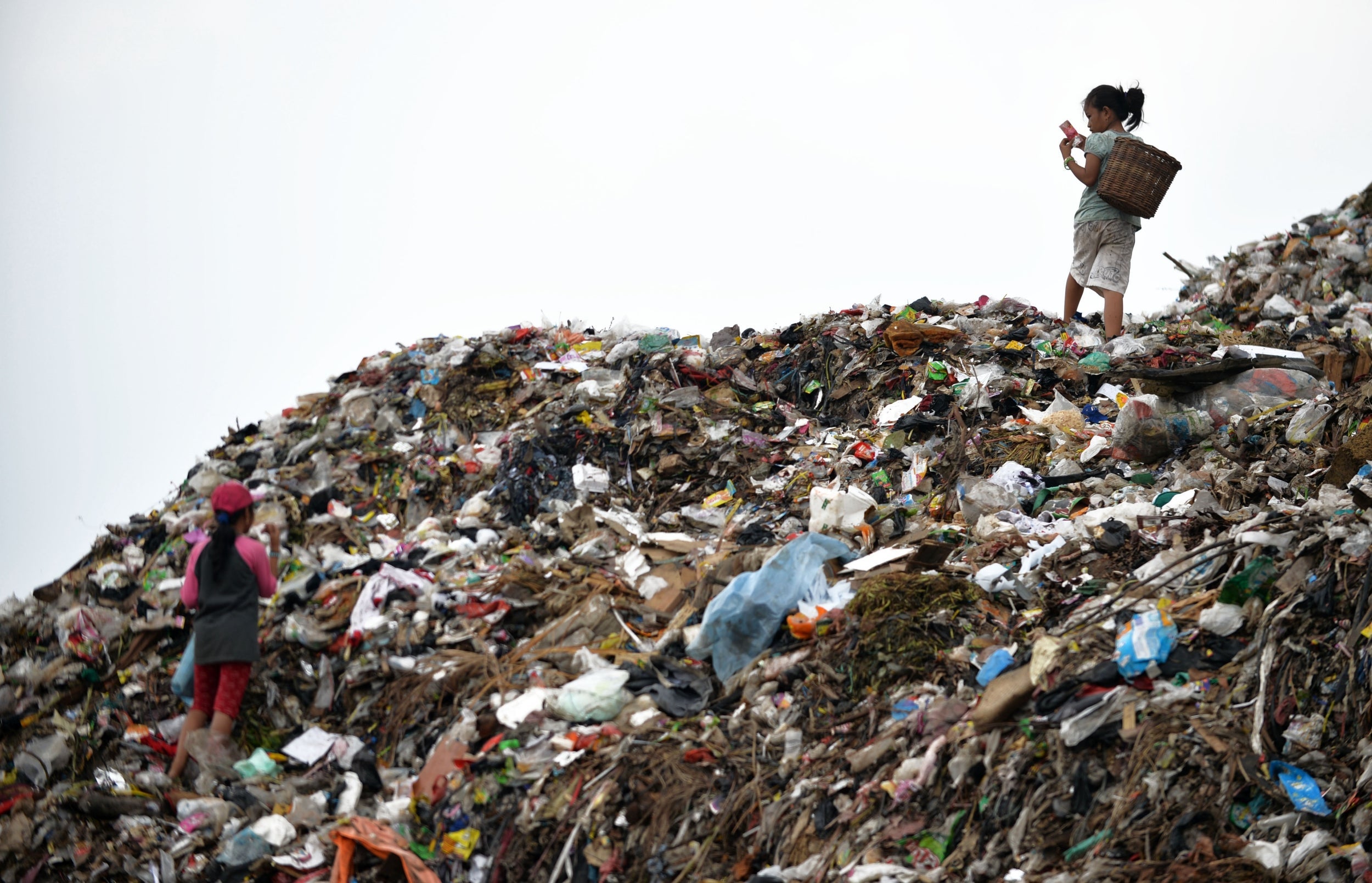 A child scavengers sorting through a pile of waste at a dump area of Bantar Gebang