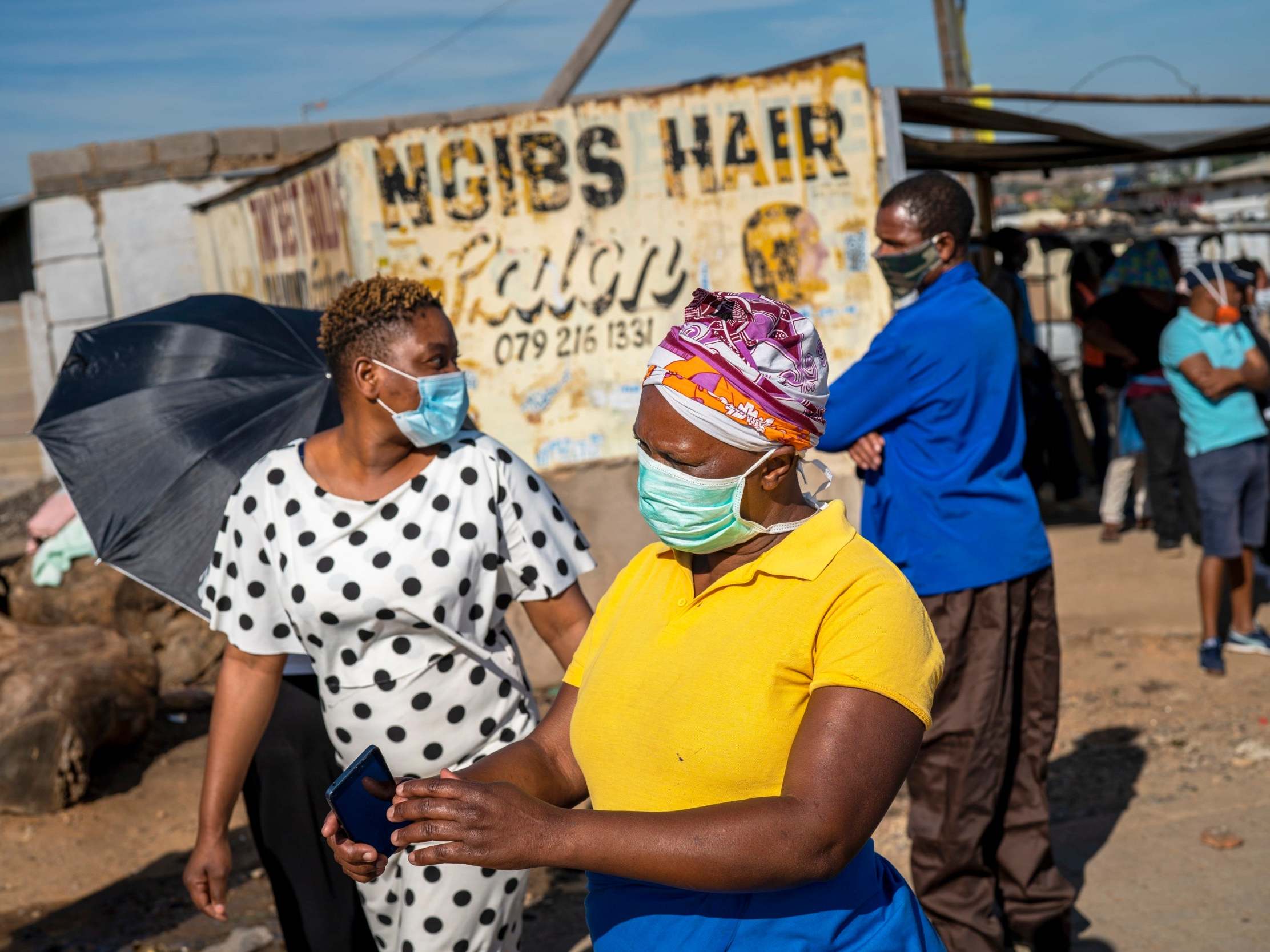 People line up to receive food handouts in the Olievenhoutbos township of Midrand, South Africa