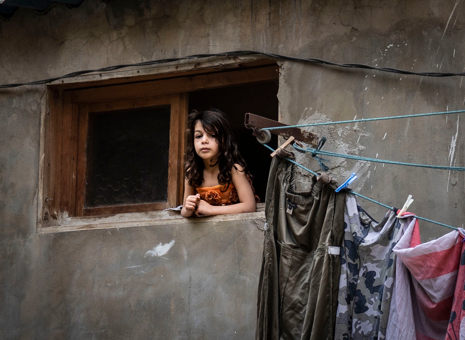 A child looks out of her window in the impoverished neighbourhood of Qobbeh, Tripoli
