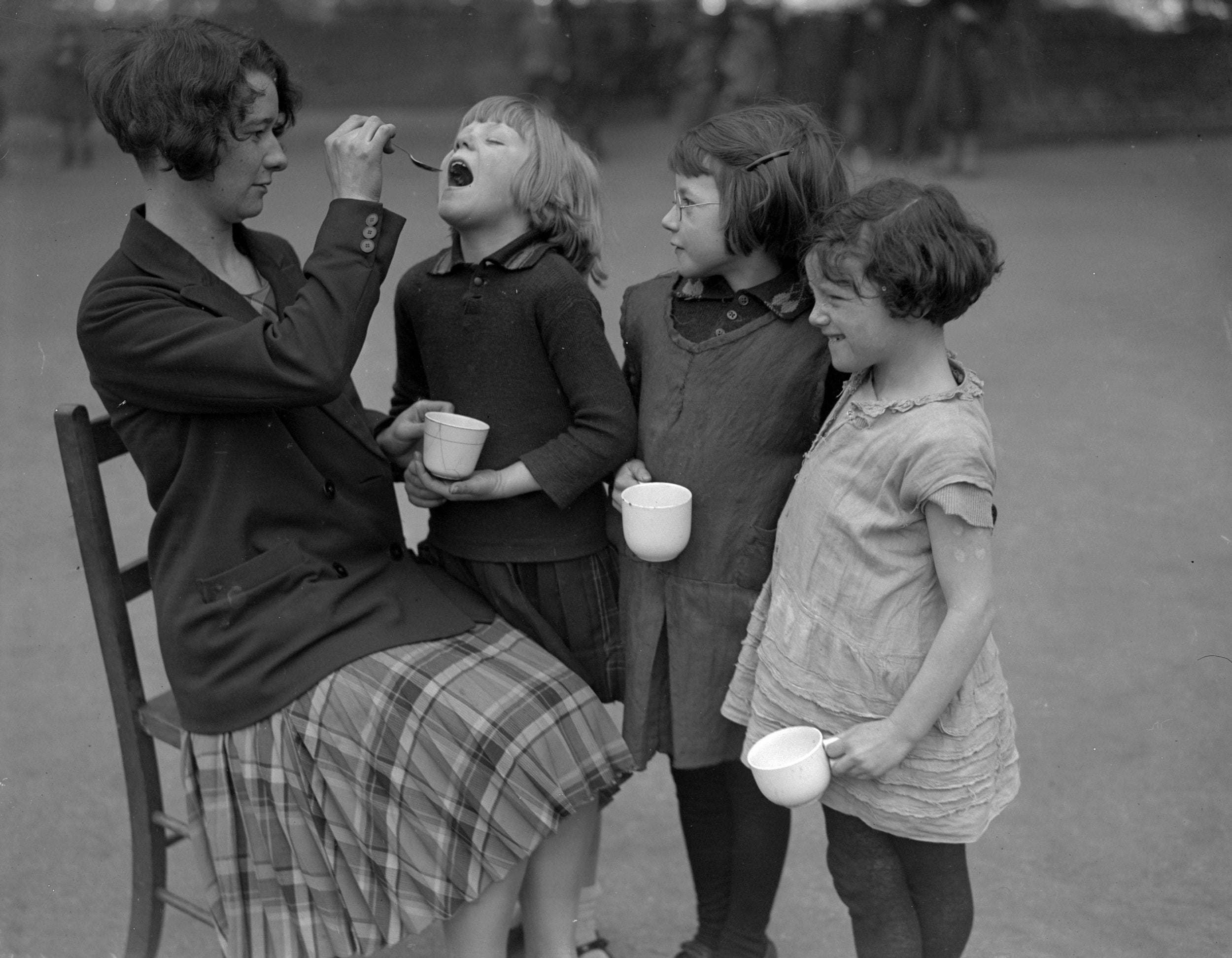 A teacher gives medicine to her pupils to guard against influenza