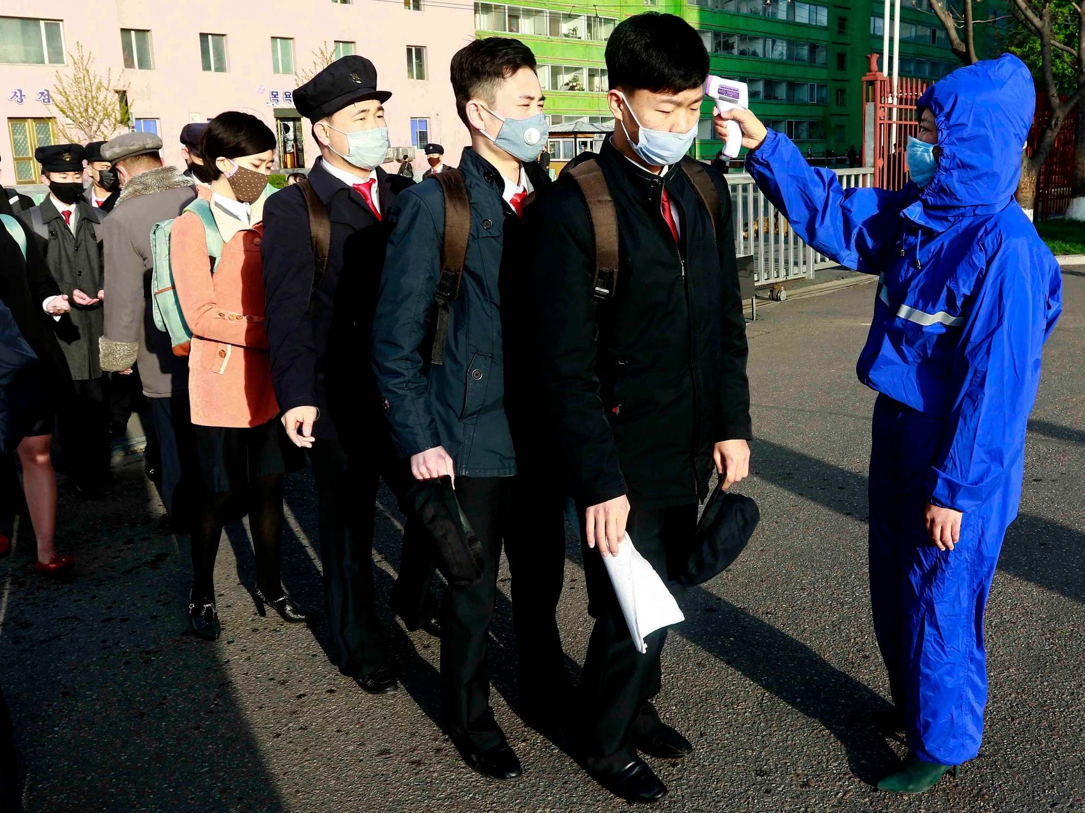 Students wearing face masks have their temperature checked as a precaution against the new coronavirus as their university reopens following the holidays at the Kim Chaek University of Technology in Pyongyang, North Korea.