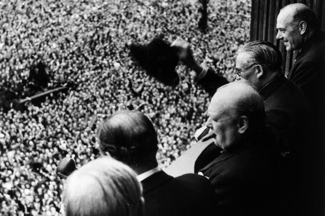 Winston Churchill waves to crowds gathered on Whitehall to mark VE Day on 8 May 1945