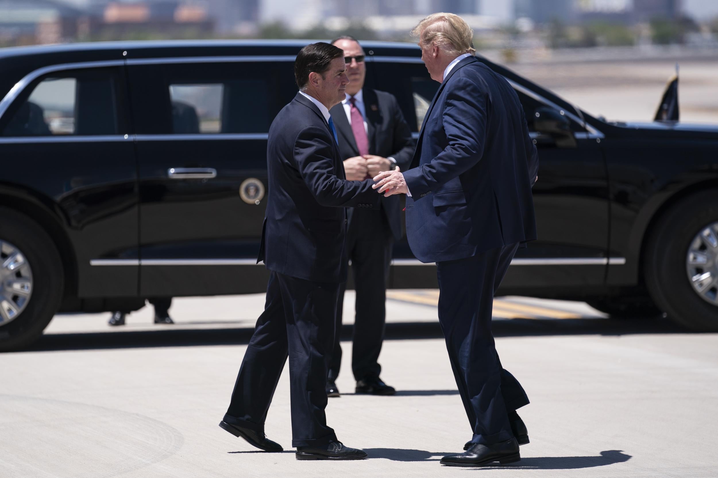 Arizona Governor Doug Ducey greets President Donald Trump as he arrives at Phoenix Sky Harbour Airport, on Tuesday, 5 May, 2020