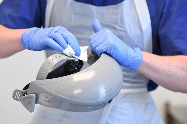 A member of clinical staff cleans and sanitizes a visor, part of the personal protective equipment (PPE) at Royal Papworth Hospital in Cambridge