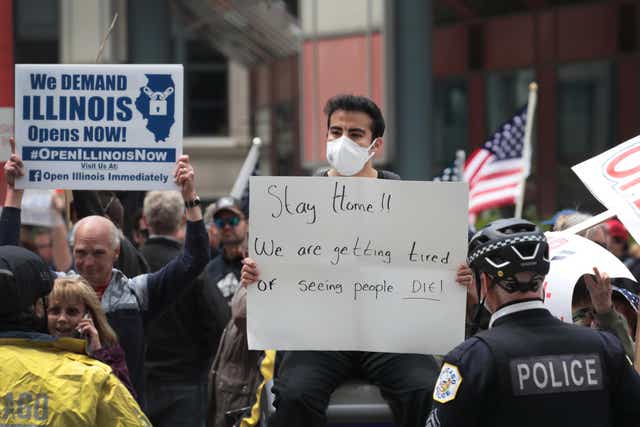 A counter-demonstrator joins in as demonstrators gather outside of Thompson Center to protest restrictions instituted by Illinois governor J B Pritzker in an attempt to curtail the spread of coronavirus Covid-19