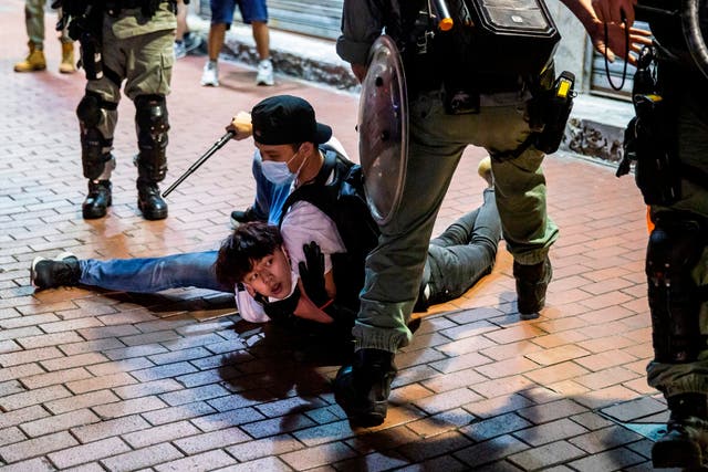 A protester is detained by an undercover officer in the Mong Kong district