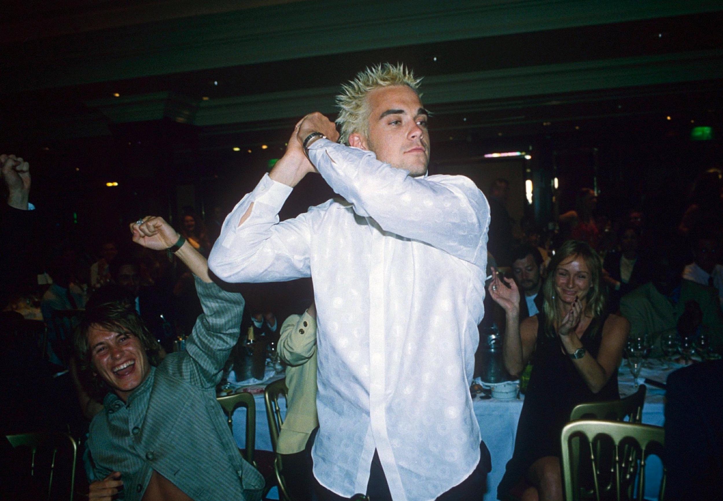 Williams and his frosted tips at an awards ceremony with Take That in 1995