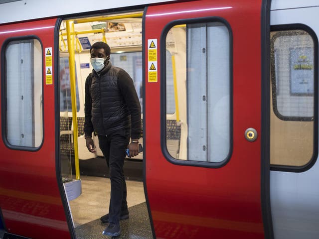 A man wears a face mask on the London Underground District line during what would normally be the evening rush hour
