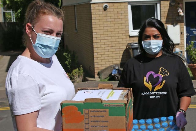Katie-Louise Barber (left) and a fellow volunteer deliver food to neighbours in need