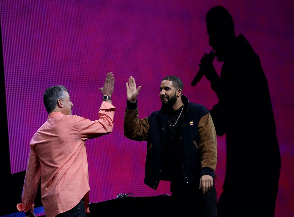 Apple's senior vice president of Internet Software and Services Eddy Cue (L) high fives with recording artist Drake during the Apple Music introduction at the Apple WWDC on June 8, 2015 in San Francisco, California