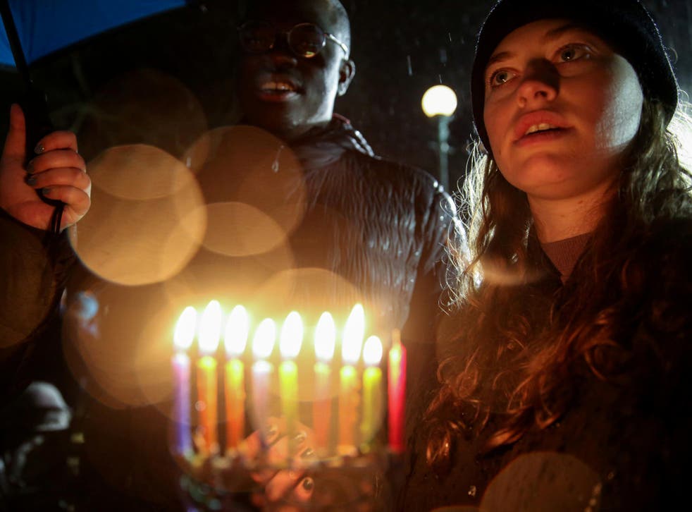 A woman holds candles while standing in solidarity with the victims after an assailant stabbed five people attending a party at an Hasidic rabbi's home in Monsey, New York