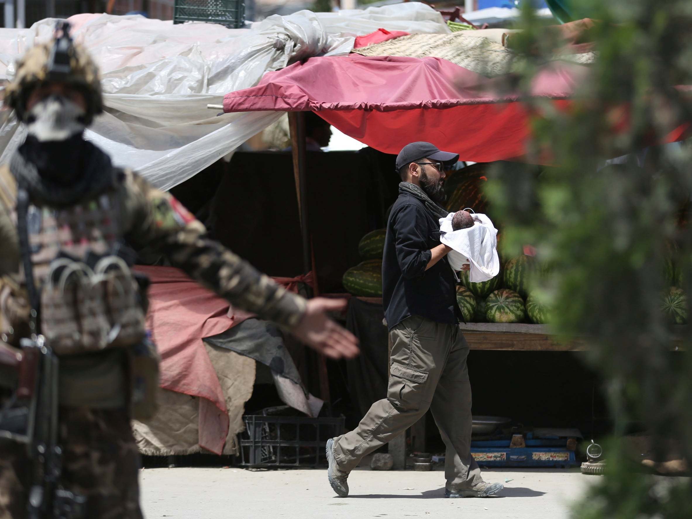 Newborn babies among dozens killed in gun attack on hospital and suicide bombing at funeral in Afghanistan