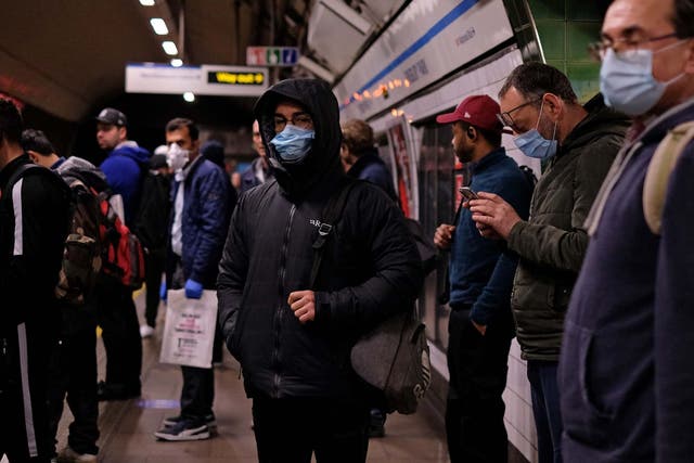Commuters wearing PPE, including a face mask as a precautionary measure against COVID-19, travel in the morning rush hour on TfL London underground Victoria Line