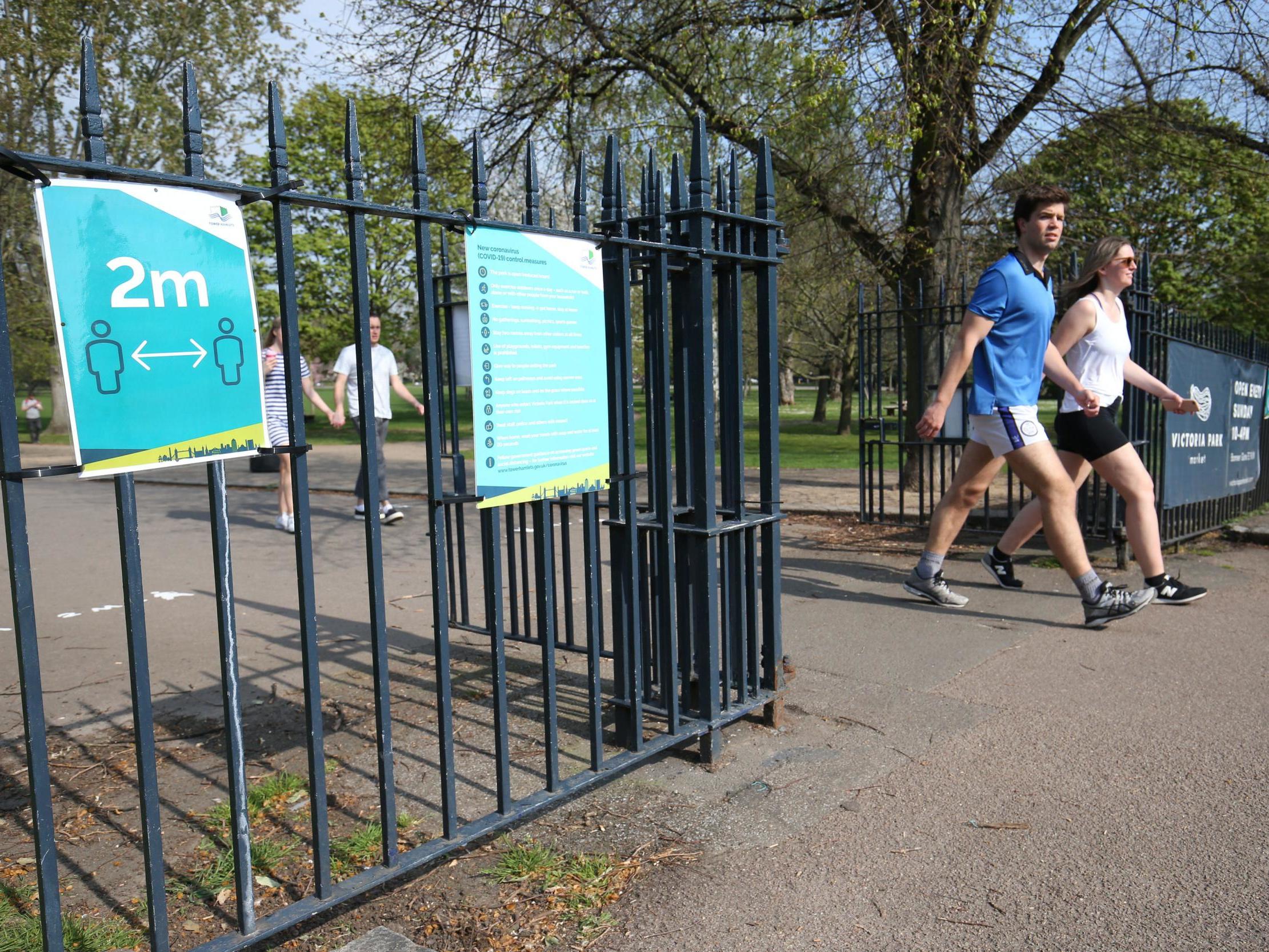 Signs on the gates reminding people to 'social-distance' at Victoria Park in east London