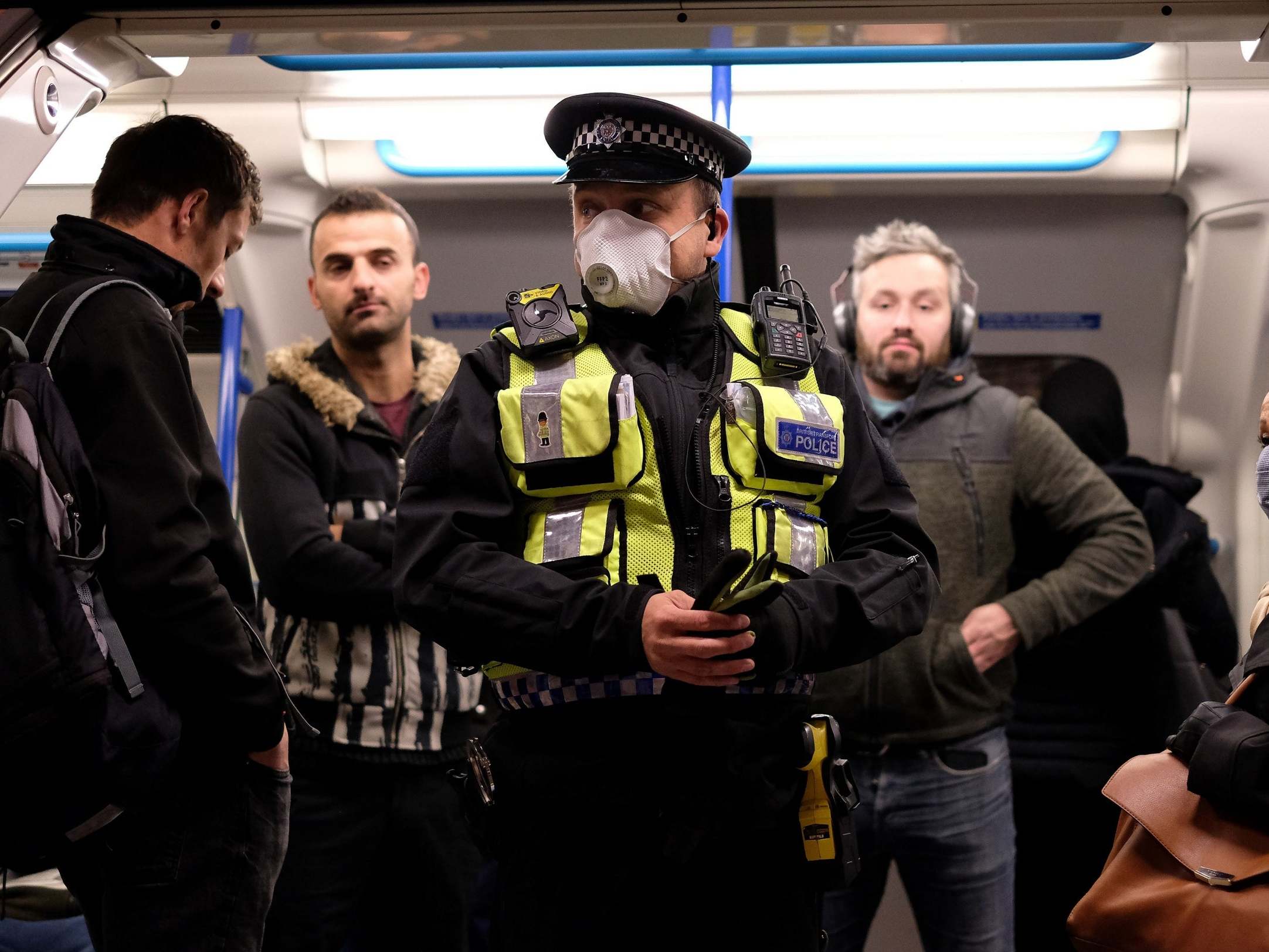 A police officer with commuters as they travel in the morning rush hour on the Victoria Line on 13 May
