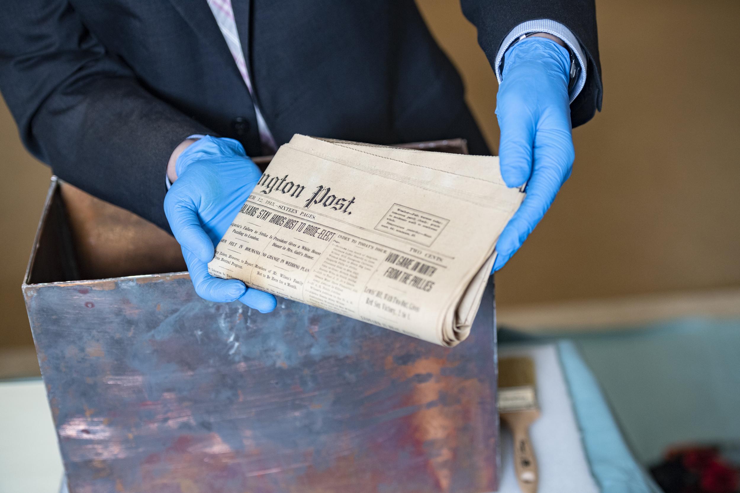 A ‘Washington Post’ newspaper dated 12 October 1915 is removed from the time capsule