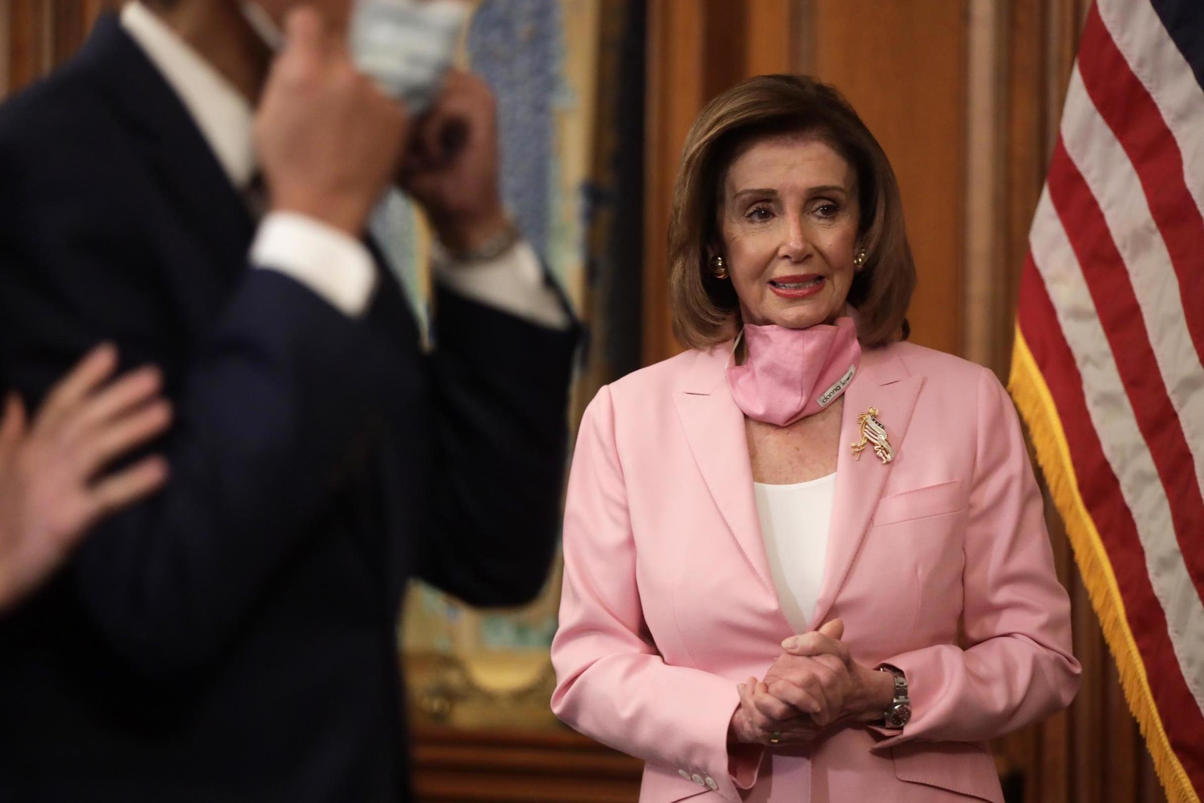 Nancy Pelosi wears a matching pink mask and pantsuit (Getty)