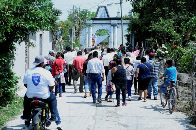 Members of the indigenous Telixtac community move the remains of a person who died after drinking allegedly adulterated alcohol in Morelos, Mexico