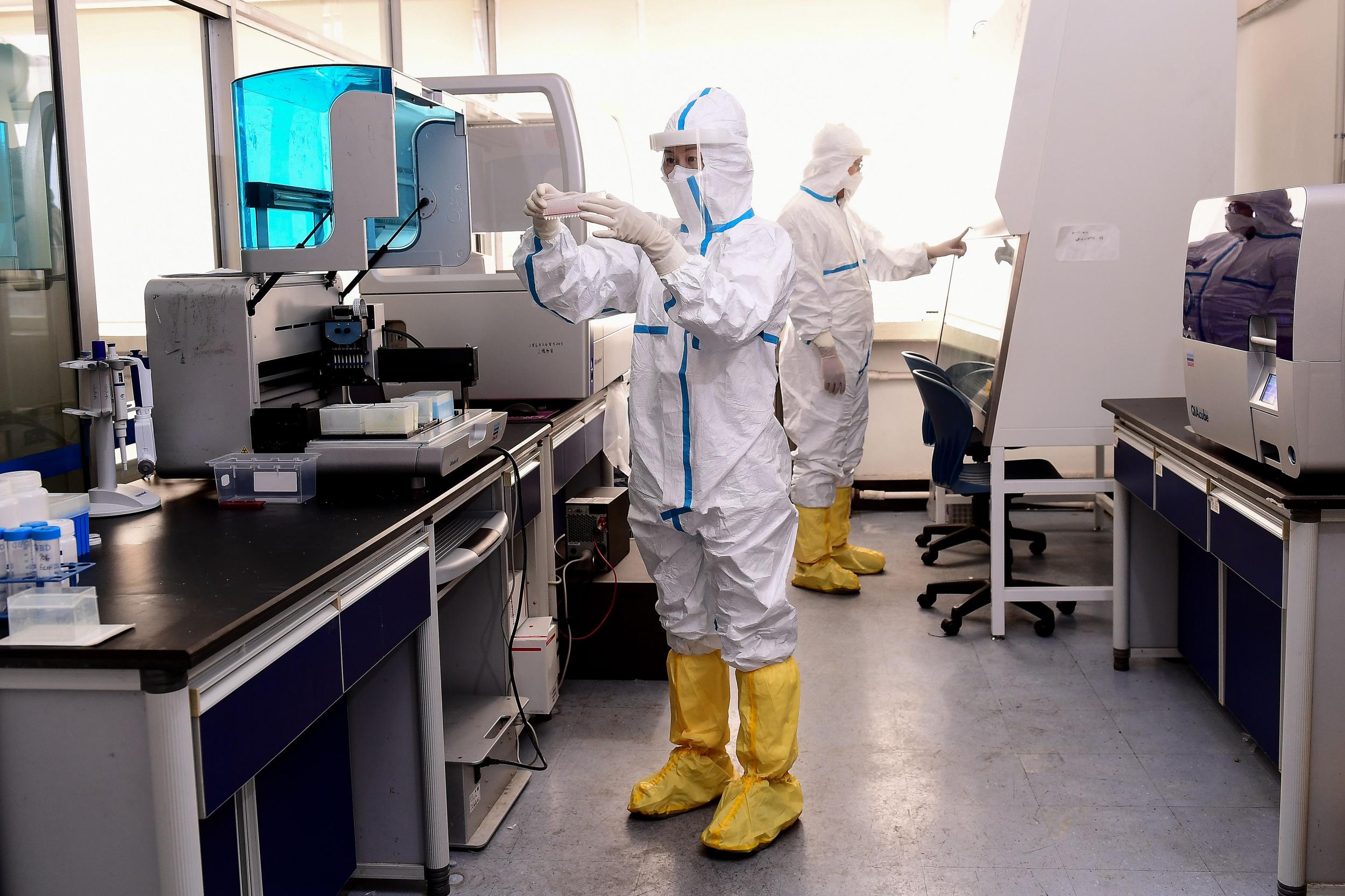 Lab technicians in Shenyang, China, work on coronavirus test samples