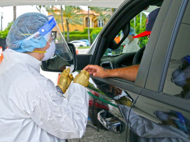 A man is tested by a health worker at a coronavirus antibody test drive-through site in Bal Harbour, Florida, US, 13 May 2020.