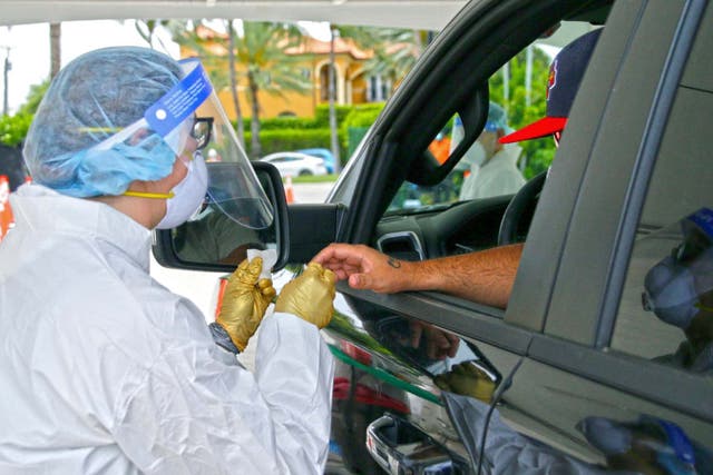 A man is tested by a health worker at a coronavirus antibody test drive-through site in Bal Harbour, Florida, US, 13 May 2020.