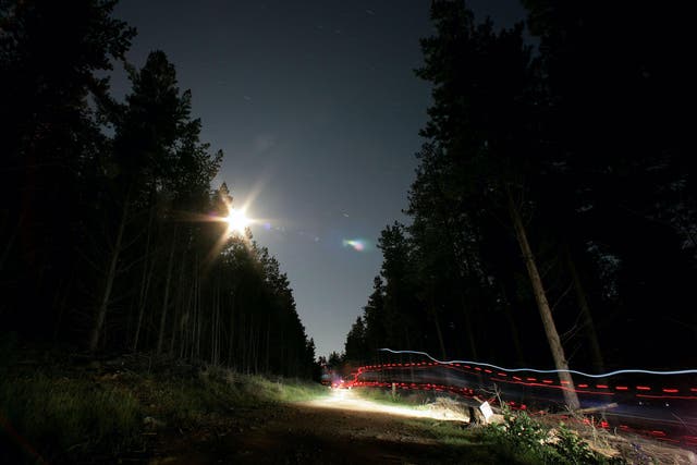 Riders leave light trails on a full-moon lit night during the Mont 24 Hour MTB Race held at Majura Pines forest