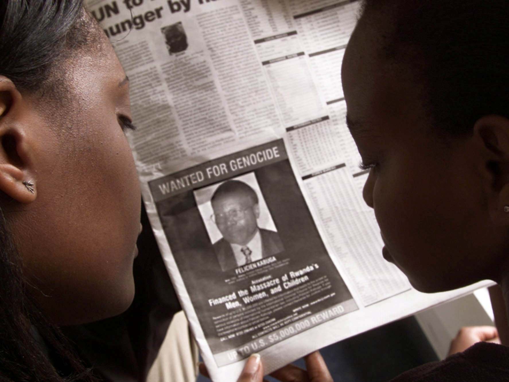 Readers look at a newspaper on 12 June 2002 in Nairobi, Kenya, carrying the photograph of Felicien Kabuga