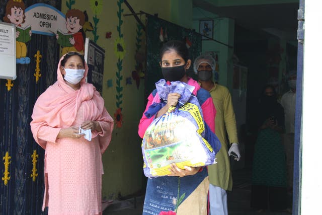 Afsana (right) collects food rations provided by a charity in eastern Delhi. She says her family has fallen into debt during the lockdown, and doesn't yet know if her mother will have work when it ends
