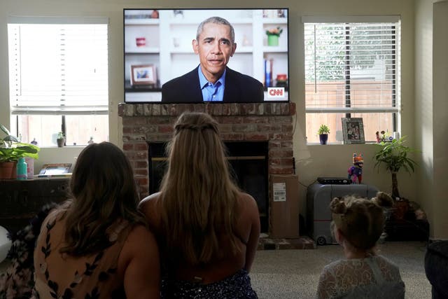 Graduating student Phoebe Seip and her sisters Sydney and Paisley watch as former president Barack Obama gives a virtual commencement address to millions of high school seniors who are missing graduation ceremonies because of the coronavirus pandemic