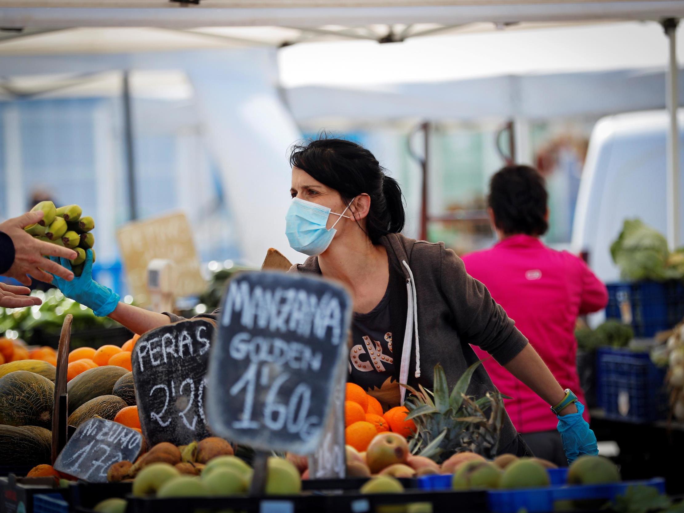 A vendor wearing a facial mask sells fruits at Landaben street market in Pamplona, Spain, on 17 May 2020.