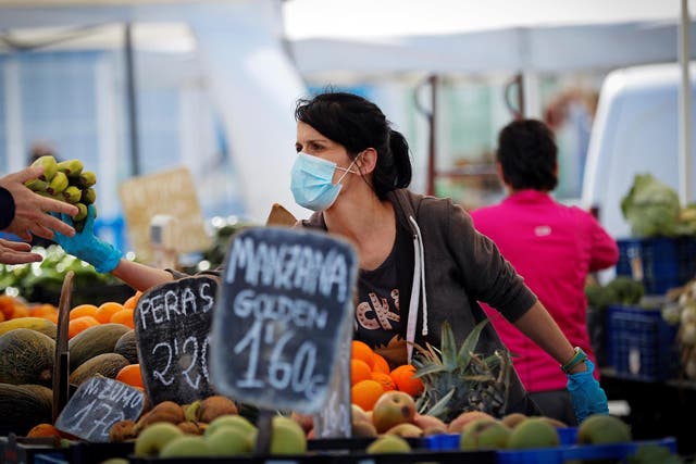 A vendor wearing a facial mask sells fruits at Landaben street market in Pamplona, Spain, on 17 May 2020.