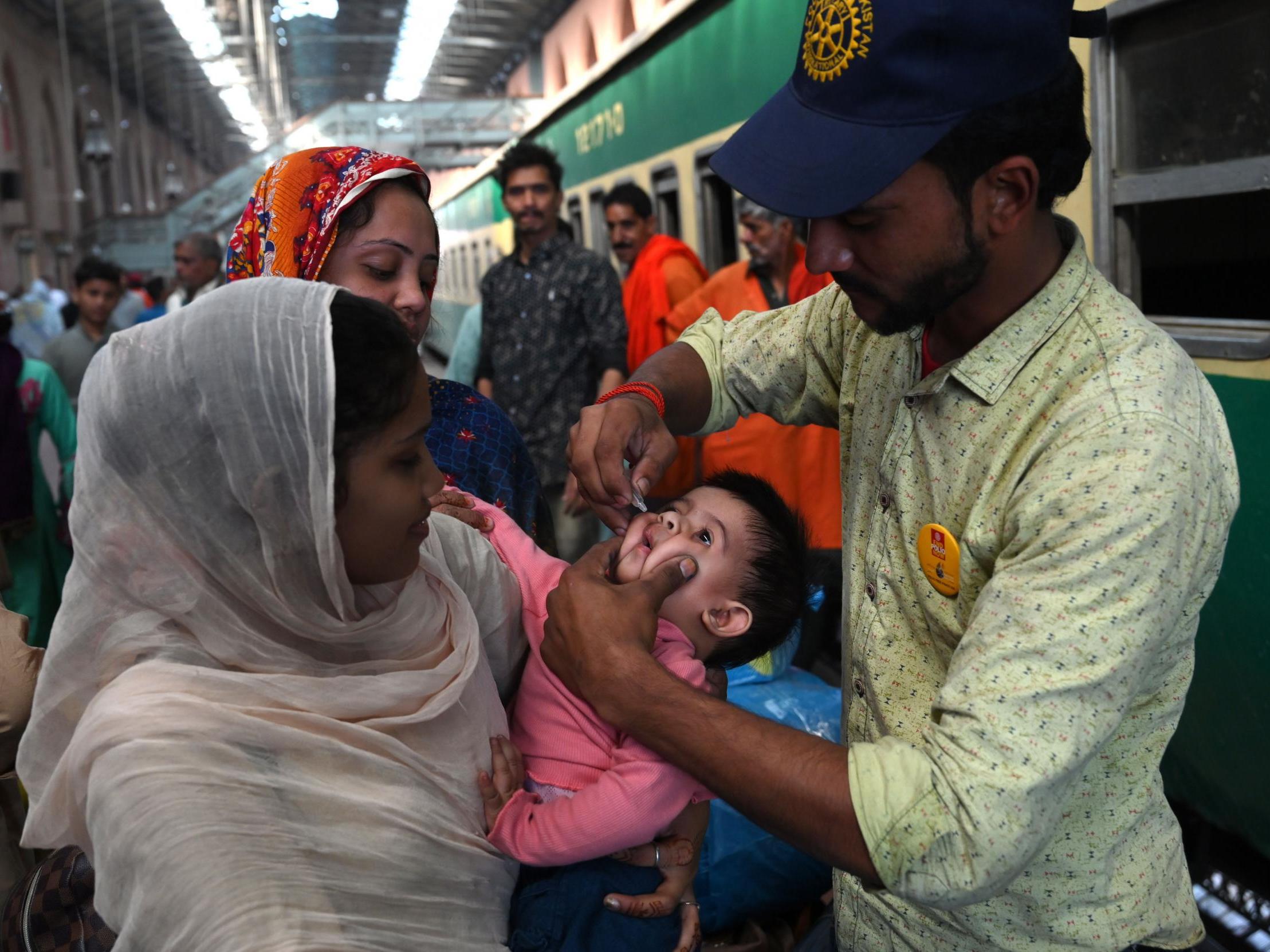 (A Pakistani health worker administers polio drops to a child at a railway station during a polio vaccination campaign in Lahore last year)