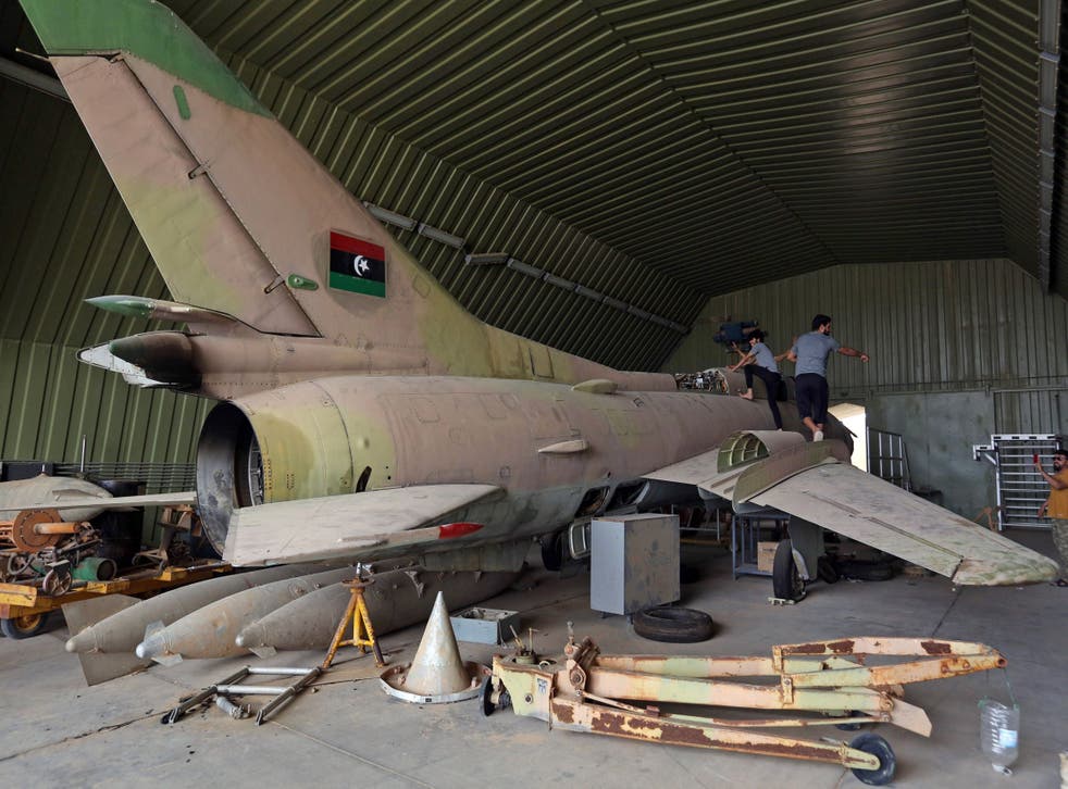 Fighters loyal to Libya's Government of National Accord climb over a partially diassembled MiG 23 aircraft, after seizing Al-Wattiya airbase, southwest of the capital Tripol