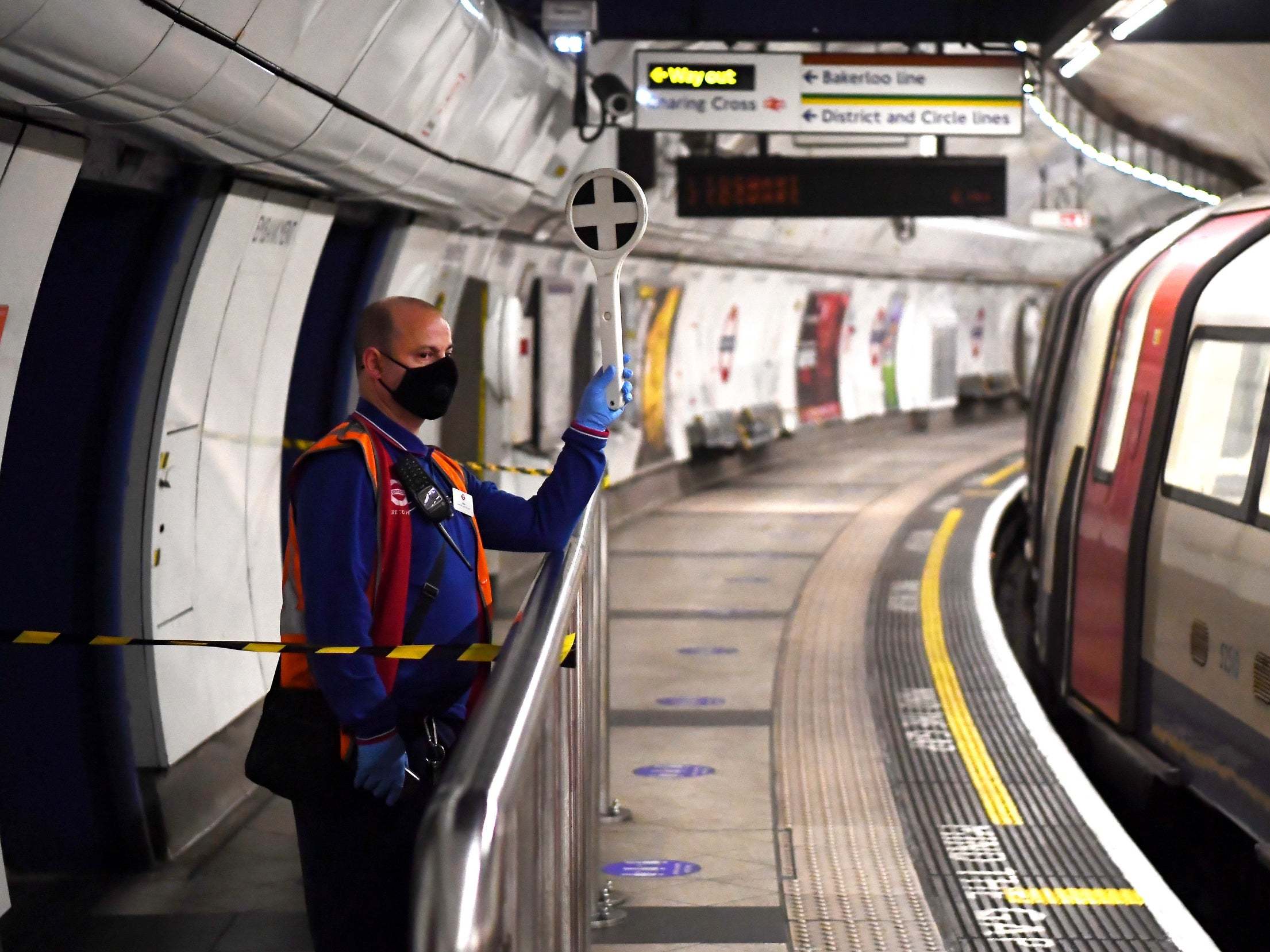 A TfL worker is seen wearing a protective facial covering at Embankment station