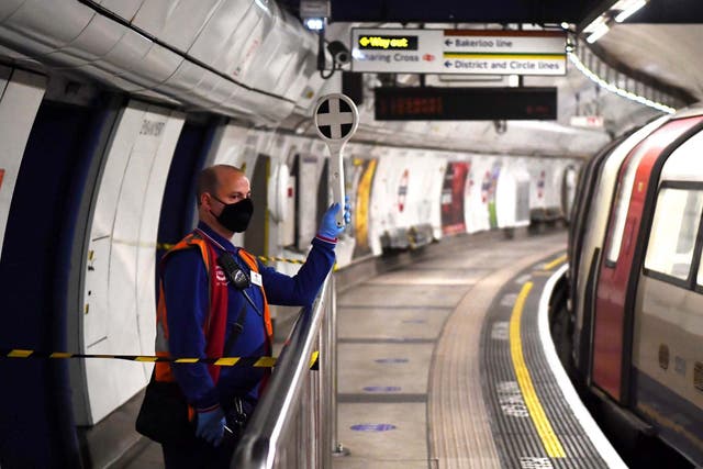 A TfL worker is seen wearing a protective facial covering at Embankment station
