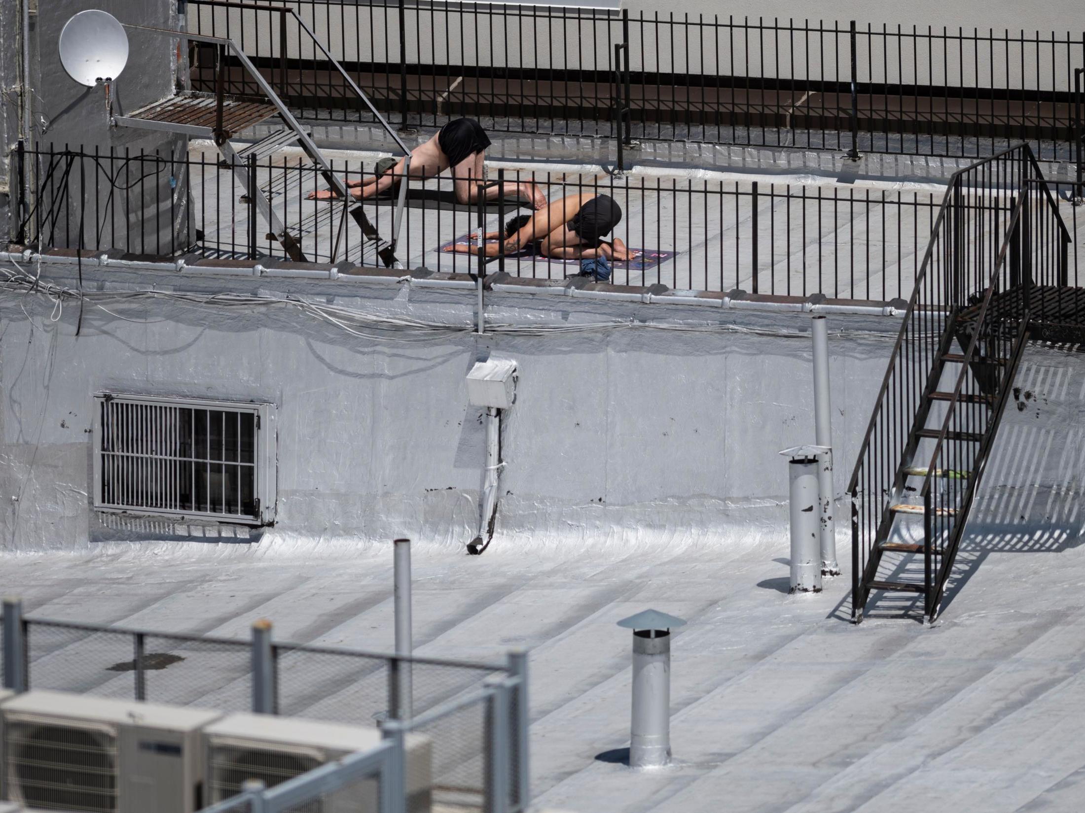 People take advantage of their rooftop to do some yoga exercises