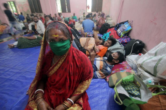 Evacuated people sit in a temporary relief shelter in Paradeep, Odisha, as Cyclone Amphan approaches