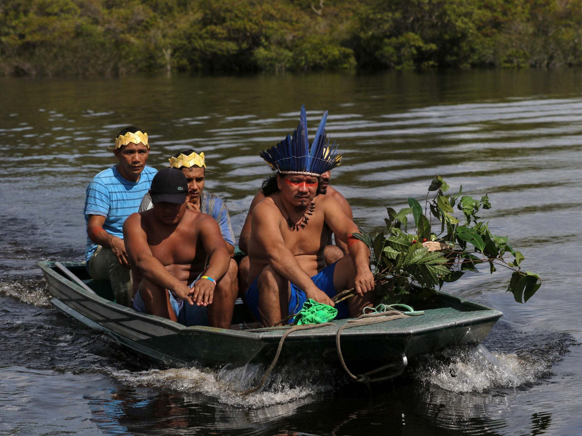 Tribal leader Andre Satere and other members of the community return home after gathering medicinal plants in the Amazon rainforest.