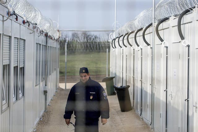 A Hungarian police officer patrols the enlarged transit zone set up for migrants at Hungary's southern border with Serbia near Tompa