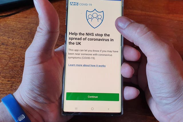  A resident of the Isle of Wight poses with his smartphone showing the NHS Coronavirus contact tracing app after it was trialled on the island