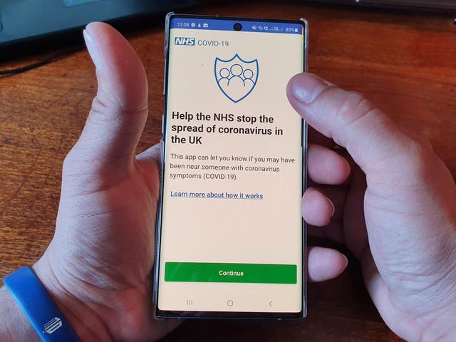 A resident of the Isle of Wight poses with his smartphone showing the newly released NHS Coronavirus contact tracing app in Ryde