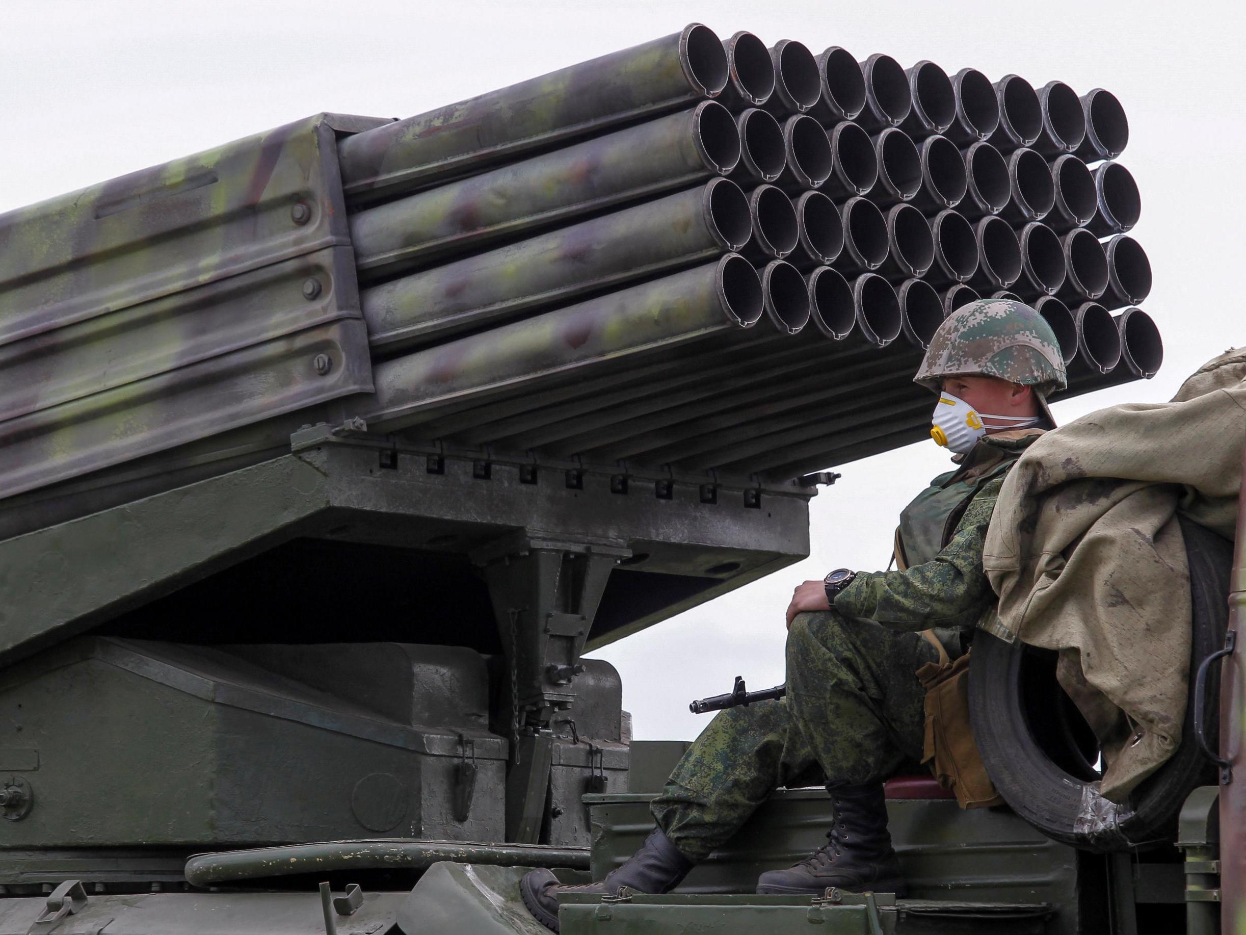 A serviceman of the self-proclaimed Donetsk People's Republic (DNR) sits on Grad multiple rocket launcher systems during military exercises at a target range outside the town of Horlivka