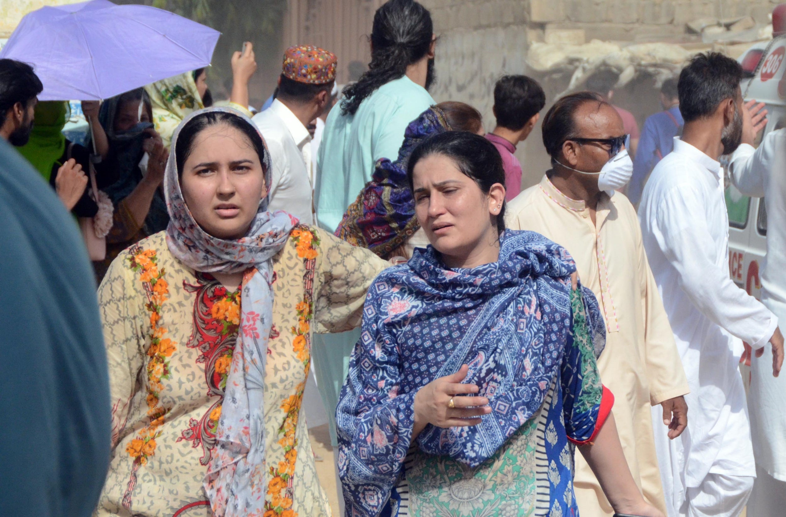 Pakistani people arrive at the site of a passenger plane crash in Karachi, Pakistan