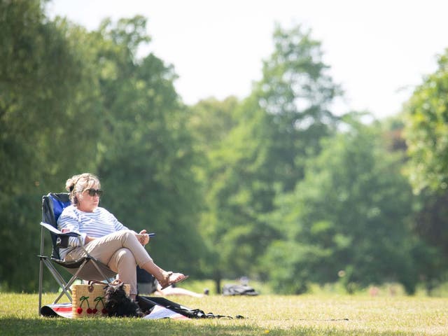 A woman relaxes in the hot weather on Clapham Common