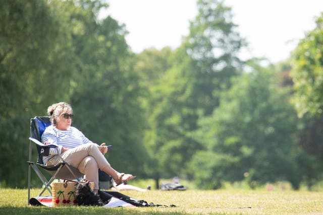 A woman relaxes in the hot weather on Clapham Common