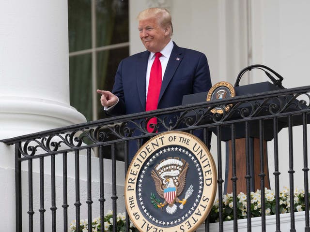 President Donald Trump points during a Rolling to Remember Ceremony to honour the nation's veterans and POW/MIA from the Blue Room Balcony of the White House on Friday 22 May 2020